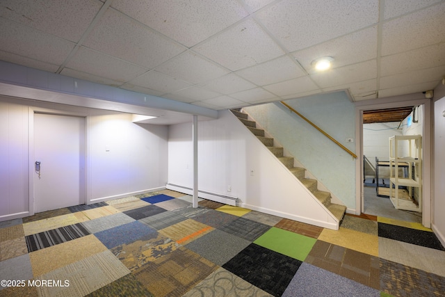 basement featuring a drop ceiling and a baseboard radiator