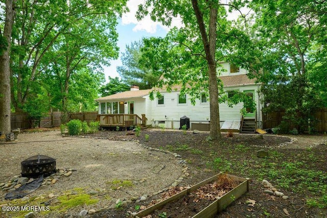 back of house with a deck and an outdoor fire pit