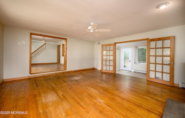 unfurnished room featuring french doors, hardwood / wood-style flooring, baseboard heating, and ceiling fan