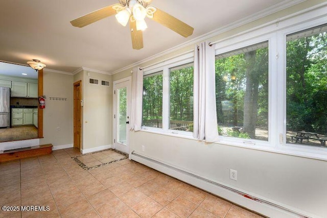 interior space with ceiling fan, ornamental molding, baseboard heating, and a wealth of natural light