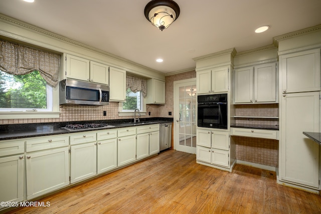 kitchen featuring appliances with stainless steel finishes, light hardwood / wood-style floors, plenty of natural light, and sink