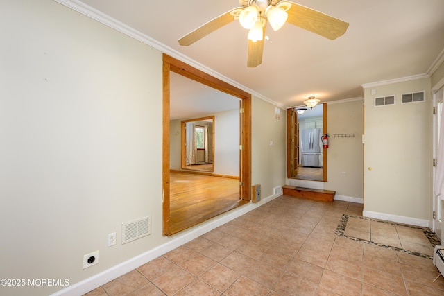 spare room featuring a baseboard heating unit, light tile patterned floors, ceiling fan, and crown molding