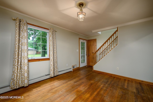 spare room featuring wood-type flooring, crown molding, and baseboard heating