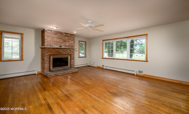 unfurnished living room featuring a fireplace, a baseboard radiator, ceiling fan, and light hardwood / wood-style floors