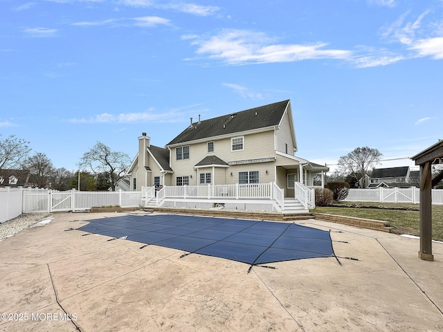 rear view of house with a swimming pool side deck and a patio