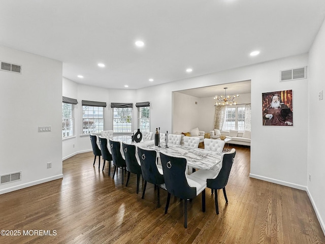 dining space featuring dark hardwood / wood-style floors, plenty of natural light, and a notable chandelier