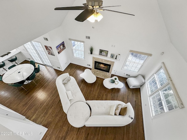 living room featuring a high end fireplace, a wealth of natural light, high vaulted ceiling, and ceiling fan