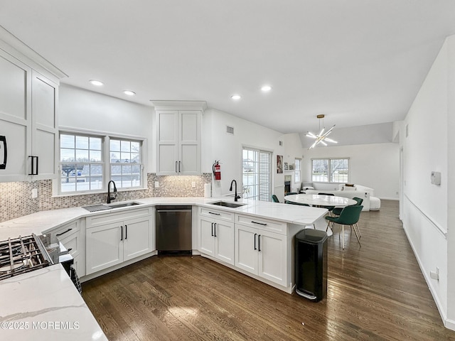 kitchen featuring stainless steel dishwasher, white cabinetry, kitchen peninsula, and sink