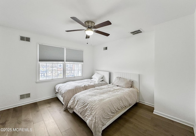 bedroom with dark hardwood / wood-style flooring and ceiling fan