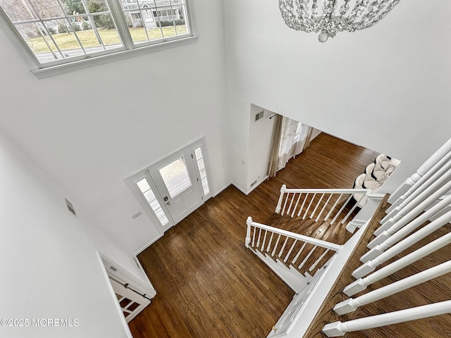 foyer entrance with dark hardwood / wood-style floors, a high ceiling, and a chandelier