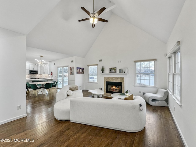 living room featuring ceiling fan, high vaulted ceiling, a premium fireplace, and dark hardwood / wood-style floors