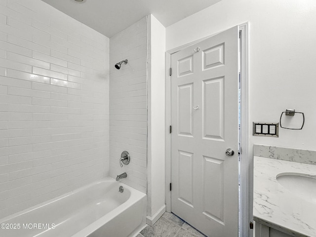 bathroom featuring tile patterned flooring, vanity, and tiled shower / bath