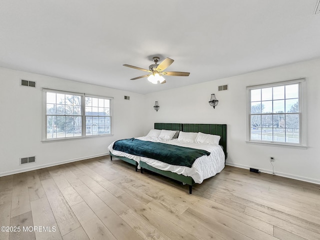 bedroom with multiple windows, light wood-type flooring, and ceiling fan