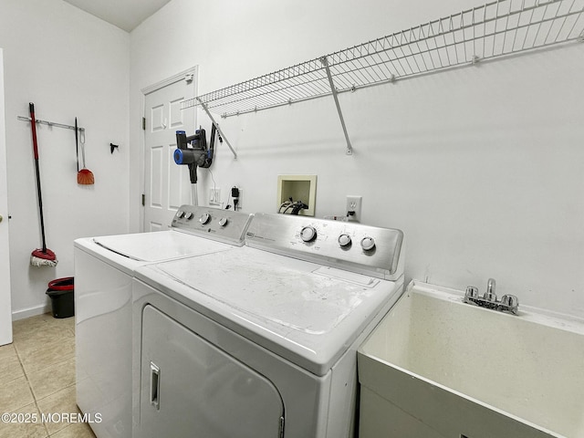 washroom featuring washer and dryer, light tile patterned floors, and sink