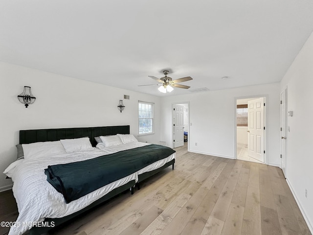 bedroom featuring light hardwood / wood-style floors, ceiling fan, and ensuite bathroom