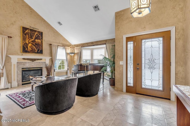 entrance foyer featuring high vaulted ceiling and a high end fireplace