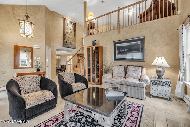 living room with a high ceiling, baseboard heating, and an inviting chandelier