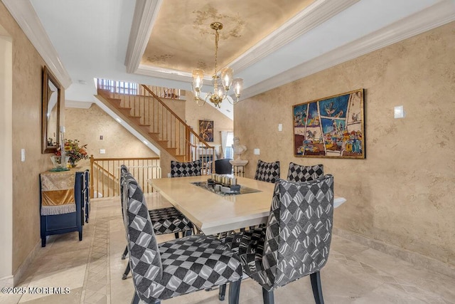 dining room featuring ornamental molding, a tray ceiling, and a chandelier