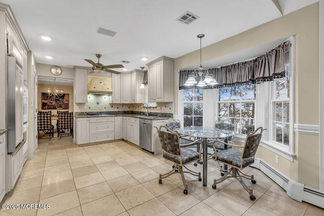 kitchen with tasteful backsplash, stainless steel dishwasher, ceiling fan with notable chandelier, a baseboard heating unit, and pendant lighting