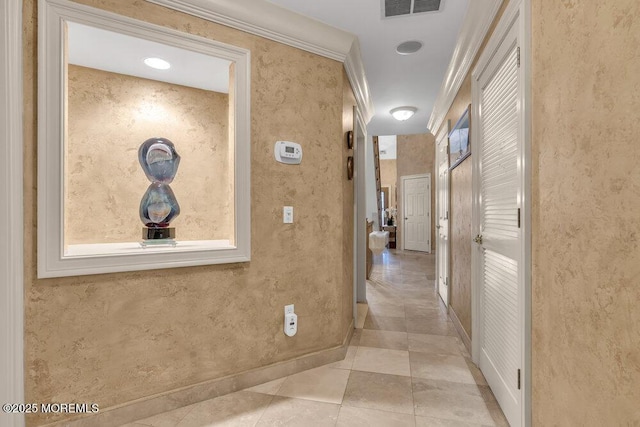 corridor featuring crown molding and light tile patterned floors