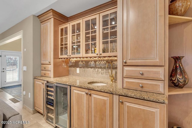 bar with light stone countertops and light brown cabinets