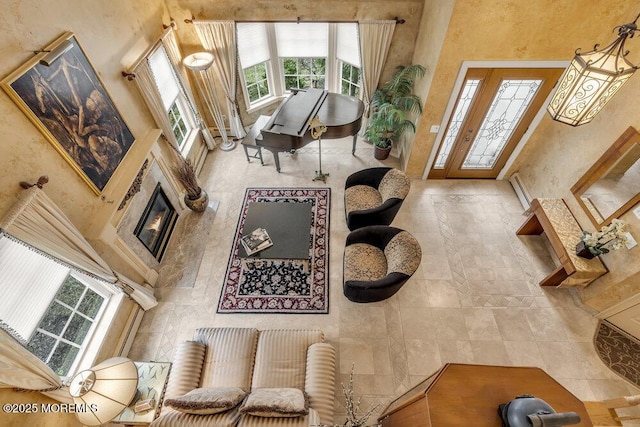 living room featuring a high ceiling and a baseboard heating unit