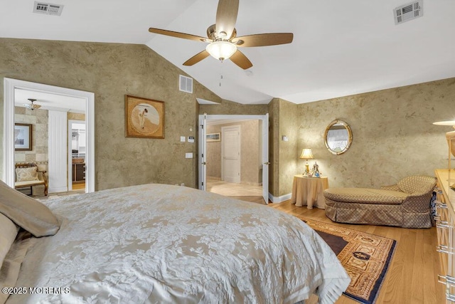 bedroom with lofted ceiling, ensuite bath, ceiling fan, and light hardwood / wood-style floors