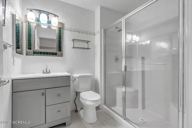 bathroom with toilet, tile walls, tile patterned floors, an enclosed shower, and vanity