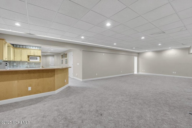 unfurnished living room featuring light colored carpet and a drop ceiling