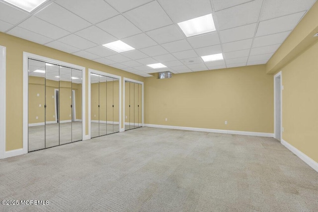 interior space featuring light colored carpet and a drop ceiling