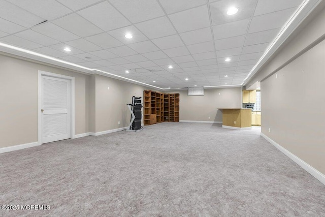 basement featuring a drop ceiling and carpet