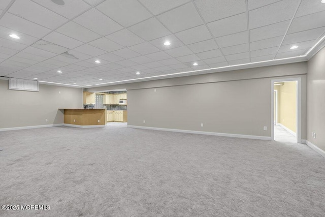 unfurnished living room with a paneled ceiling and carpet flooring