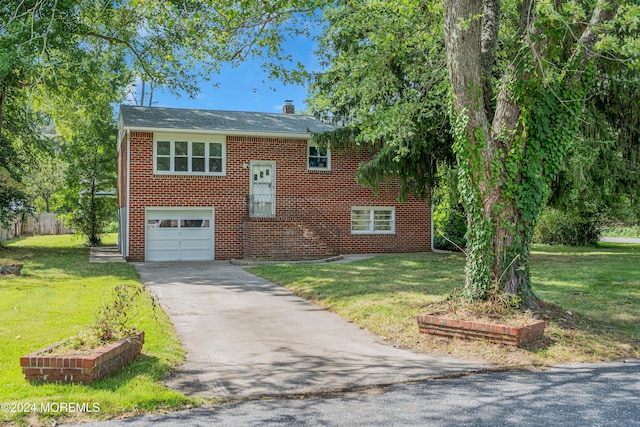 bi-level home with a garage and a front lawn