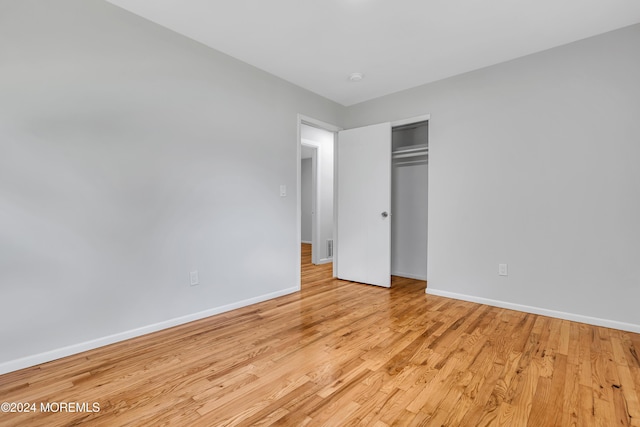 unfurnished bedroom featuring a closet and light hardwood / wood-style floors