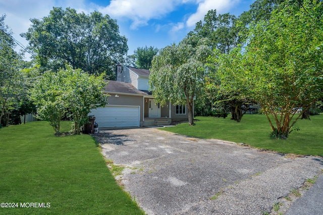 obstructed view of property featuring a front lawn and a garage