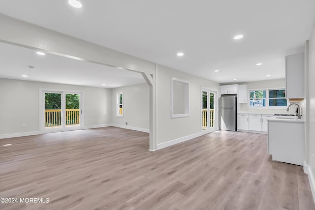 unfurnished living room featuring light hardwood / wood-style flooring and sink