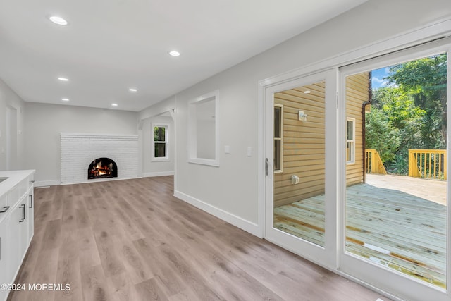 unfurnished living room with a fireplace and light hardwood / wood-style flooring