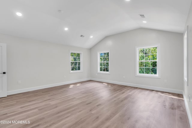 spare room featuring light hardwood / wood-style flooring and vaulted ceiling