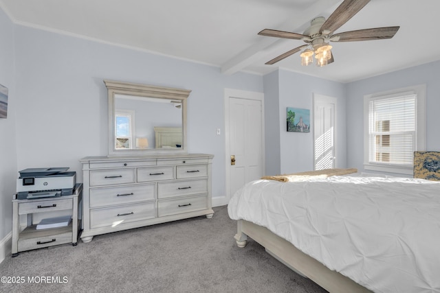 carpeted bedroom with ceiling fan and beam ceiling