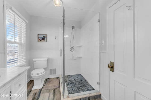 bathroom with hardwood / wood-style flooring, an enclosed shower, vanity, and toilet