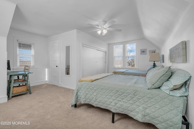 bedroom with ceiling fan, light colored carpet, a closet, and multiple windows