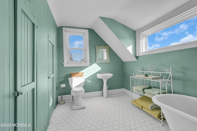 bathroom featuring toilet, tile patterned flooring, vaulted ceiling, a washtub, and radiator heating unit