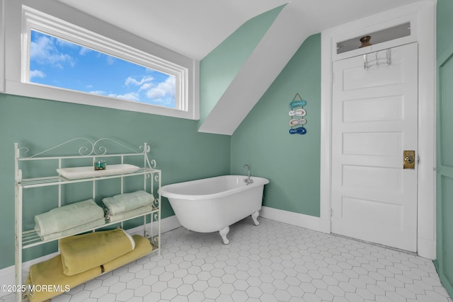 bathroom with tile patterned flooring, vaulted ceiling, and a bath