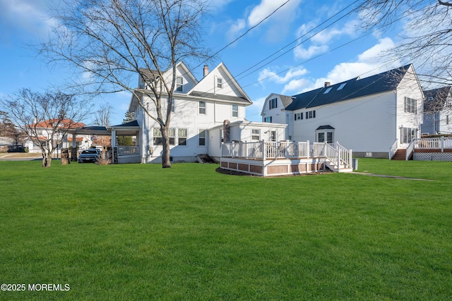 back of property with a wooden deck and a yard