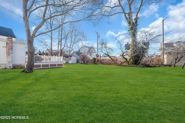 view of yard featuring a storage unit and a deck