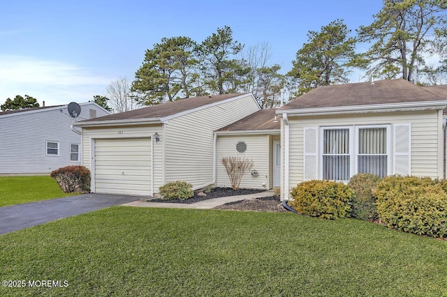 ranch-style home featuring a garage and a front lawn