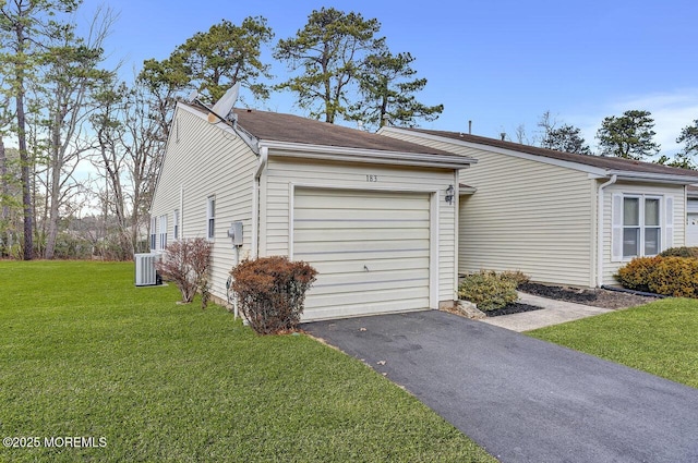 garage with a lawn and cooling unit