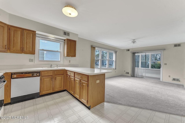 kitchen featuring kitchen peninsula, white dishwasher, light colored carpet, ceiling fan, and sink