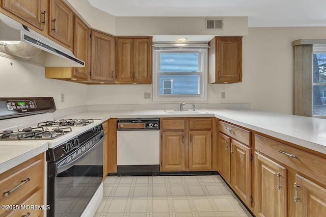 kitchen with kitchen peninsula, white appliances, and sink