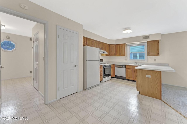 kitchen with kitchen peninsula, white appliances, a breakfast bar area, and sink